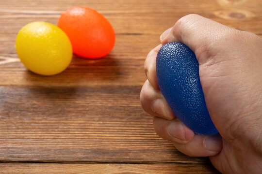 man doing exercises by squeezing a rubber hand trainer