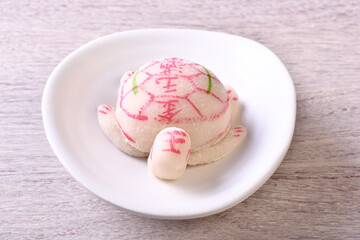 Prosperity Turtle cake on white plate, The Chinese words on the Prosperity Turtle cake means gold...