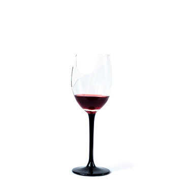 Broken wineglass with remnants of red wine isolated on white background.