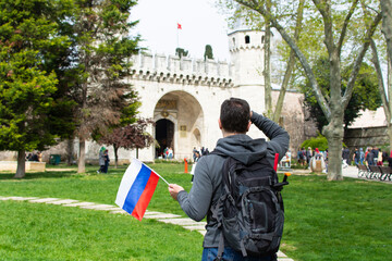 Obraz premium Russian tourist man with backpack looking at Topkapı palace gates. Tourism in Europe, Asia, Turkey, Istanbul concept. Russian tourists in Turkey.