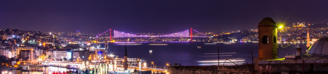 Panoramic view of 15th July Martyrs Bridge (15 Temmuz Sehitler Koprusu) aka: Bosphorus Bridge at night time from Suleymaniye district. Istanbul, Turkey.