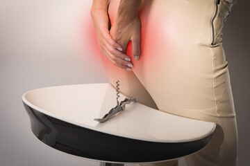 The pain caused by hemorrhoid. Woman suffering from hemorrhoid. Woman hands holding her bottom...