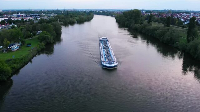Aerial view of a transport ferry on the Main river,  sunny evening, in Raunheim, Germany - reverse drone shot