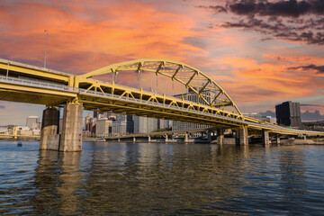 Downtown urban waterfront and Route 279 bridge with sunset sky in Pittsburgh, Pennsylvania.