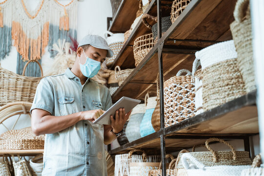 male business owner keep working and wear face masks at his art and craft store