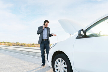 Latin man calling for help to fix his dead car