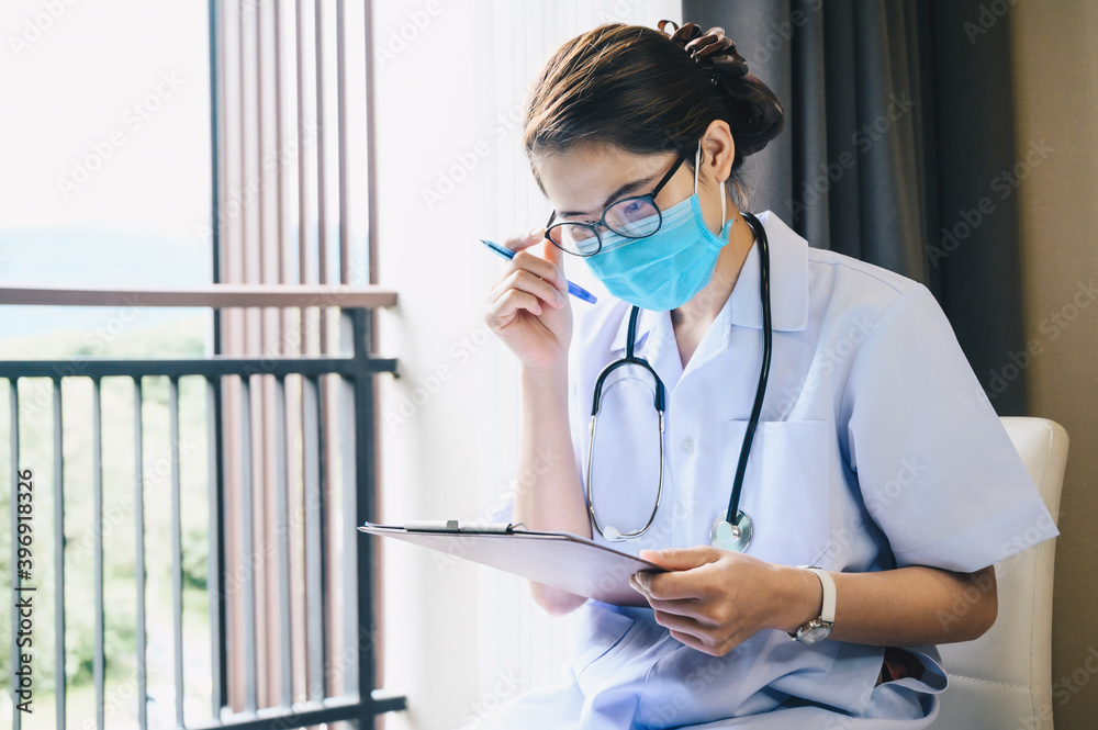 Wall mural asian healthcare worker reading patient medical history about diagnosis and prescriptions.