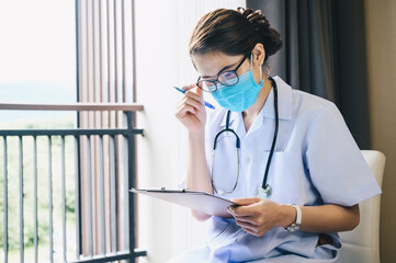 Asian healthcare worker reading patient medical history about diagnosis and prescriptions.