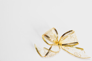 A golden bow. Festive background. New Year. Christmas. selective focus on bow. free space for text.