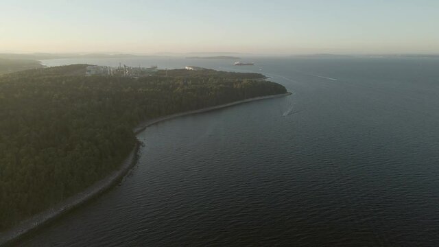 Coastline in Southern Norway, oil refinery and cargo ship in a far. Drone footage