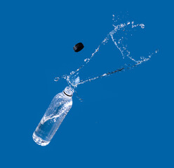 Water splash out of bottle on a blue background