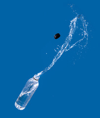 Obraz na płótnie Canvas Water splash out of bottle on a blue background