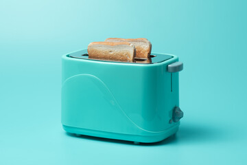 Toaster with bread slices on mint green background