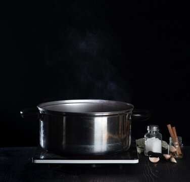 Steam over cooking pot on dark background