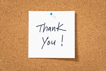 White thank you post note pinned on corkboard