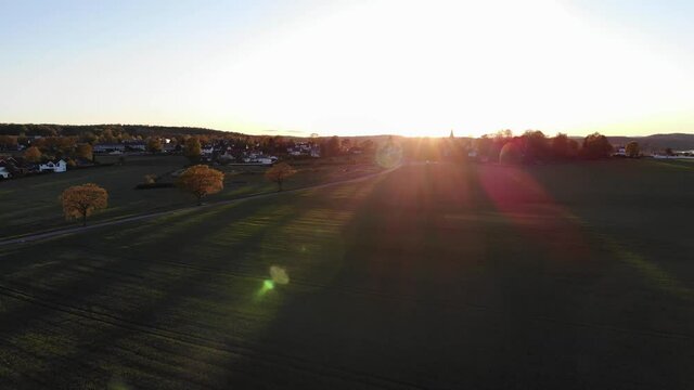 Rotating drone footage over corn field and road. Flare from the sun