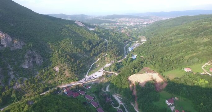 Small Village Outside of Novi Pazar Next to Mountain With Forests and Car Driving, Aerial Forward Tilt Up