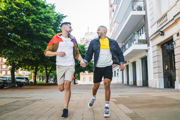 Gay couple holding their hands and running together.