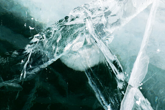Abstract texture of broken white ice and dark water at winter. Cracked ice.