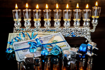Cash gift with burning menorah for Hanukkah.