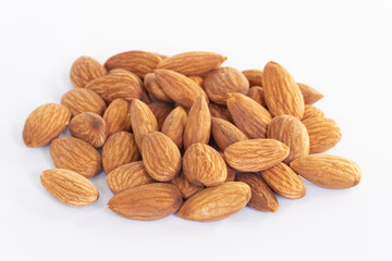 Pile of almonds seeds isolated on white background. Focus closeup group of nuts.