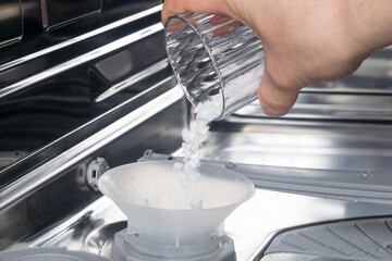 the process of adding salt to the dishwasher, close-up
