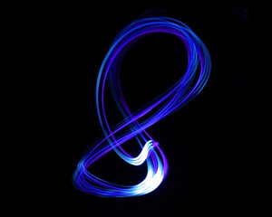 Colorful Neon light painting effect. Abstract luminous swirl tail Lights shape at motion on...