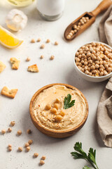 Hummus in a wooden plate with parsley and croutons. Dishes of chickpeas, a vegetarian dish.