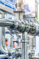 Industrial stainless steel piping connected by special nuts.