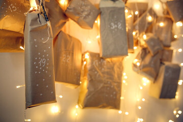 Magical homemade advent calendar on a tree branch on the wall of the house, holiday decor and tasks...
