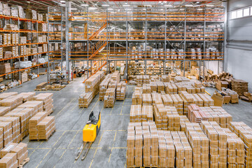 Large industrial warehouse. Many cardboard boxes stand on a loading dock