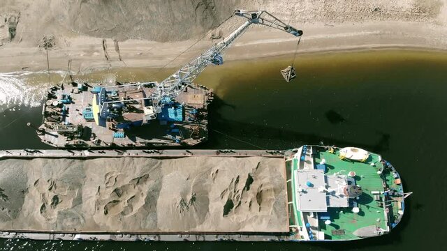 A dredger is dragging sand to the shore&nbsp;from&nbsp;a scow