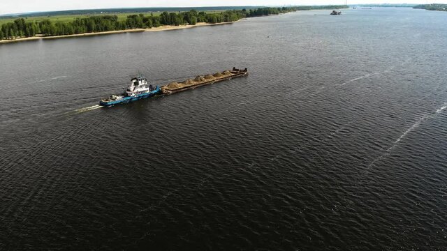 A dump scow transports sand&nbsp;down&nbsp;the river