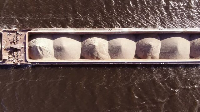 A dump scow transports sand&nbsp;down&nbsp;the river