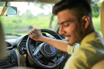 Young indian man driving a new car