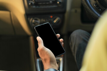 male hand holding mobile phone in car