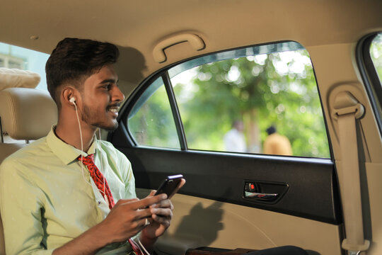 Young Indian Man Listening Music On Mobile Phone In Car