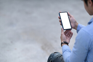 Mockup image of man hands holding mobile phone with blank screen for your text message or information content.