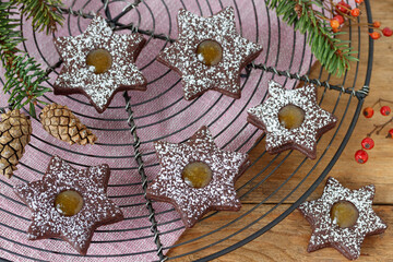 Weihnachtsplätzchen Schokoladen-Sterne mit Orangenmarmelade auf Kuchengitter