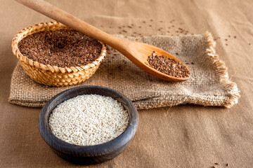 Vintage illustration of flax seeds in a wicker basket, sesame with a wooden spoon on a table with a brown tablecloth, top view. The concept of a healthy lifestyle, organic life in a rustic style.