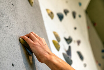 Hand on holds at climbing wall