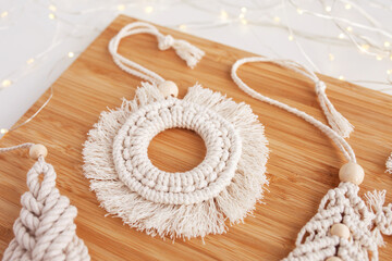 Fototapeta na wymiar Christmas macrame decor. Christmas present in the style of macramé. Natural materials - cotton thread, wood beads. Eco decorations, ornaments, hand made decor. Winter and New Year holidays