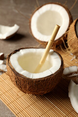 Tasty coconut with straw on bamboo background