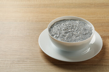 Bowl with chia pudding on wooden background