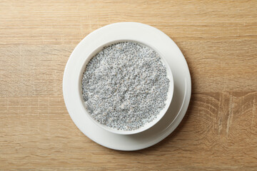Bowl with chia pudding on wooden background