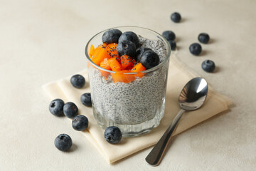 Glass with delicious chia pudding on white table