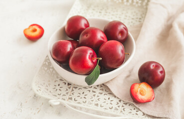 Naklejka na ściany i meble Bowl with fresh ripe plums on table