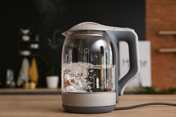 Electric kettle with boiling water on kitchen table