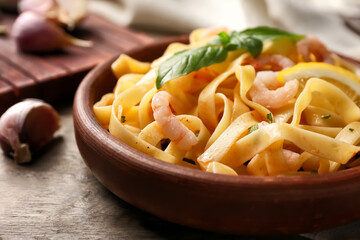 Plate of tasty pasta with shrimps on wooden table, closeup