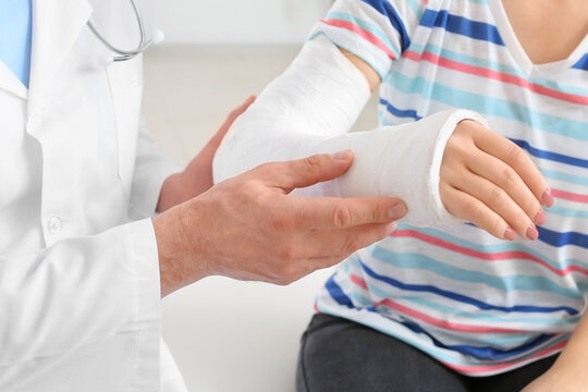 Young woman with broken arm visiting doctor in clinic